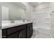 A full bathroom with double sinks, dark cabinets, and a shower/tub combo at 9366 E Sequence Ave, Mesa, AZ 85212