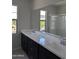 Elegant bathroom featuring a double sink vanity, dark wood cabinets, quartz countertop, and a large mirror, with outside views at 9366 E Sequence Ave, Mesa, AZ 85212