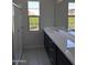 Modern bathroom features a double vanity, sleek dark cabinetry, quartz countertops, a glass-enclosed shower, and outdoor views at 9366 E Sequence Ave, Mesa, AZ 85212