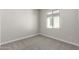 A carpeted bedroom with a window and neutral walls, offering a blank canvas for personalization and comfort at 9366 E Sequence Ave, Mesa, AZ 85212
