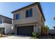 New home featuring a two-car garage, low maintenance landscaping, neutral exterior, and long driveway at 9366 E Sequence Ave, Mesa, AZ 85212
