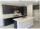 Modern kitchen features an island, black cabinetry, stainless steel appliances, and stylish backsplash, ideal for cooking at 9366 E Sequence Ave, Mesa, AZ 85212