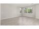 Spacious living room with wood look flooring, large windows, and neutral colored walls at 9366 E Sequence Ave, Mesa, AZ 85212