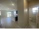 Open-concept living space flows into a sleek kitchen, with a view of a half-bathroom and a serene outdoor patio at 9366 E Sequence Ave, Mesa, AZ 85212