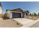 Charming home features low maintenance desert landscaping and a gray two-car garage at 9416 E Sequence Ave, Mesa, AZ 85212