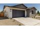 Charming home features low maintenance landscaping, gray two-car garage and a concrete driveway at 9416 E Sequence Ave, Mesa, AZ 85212