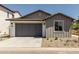 Home features low maintenance landscaping, gray two-car garage and a concrete driveway at 9416 E Sequence Ave, Mesa, AZ 85212