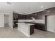 Open-concept kitchen with stainless steel appliances, dark cabinets, and white countertop island at 9416 E Sequence Ave, Mesa, AZ 85212