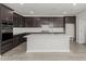 Modern kitchen features dark wood cabinets, subway tile backsplash, and a white island with sink at 9416 E Sequence Ave, Mesa, AZ 85212