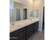 Main bathroom featuring dual sinks, dark cabinetry, and a large mirror at 9416 E Sequence Ave, Mesa, AZ 85212