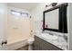 Stylish bathroom with granite countertop, decorative mirror, and tub with shower at 11030 N 47Th Ave, Glendale, AZ 85304