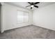 Neutral carpeted bedroom with ceiling fan and window at 11030 N 47Th Ave, Glendale, AZ 85304