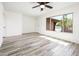 Bright bedroom with wood floors, a ceiling fan, and a large window with backyard views at 11030 N 47Th Ave, Glendale, AZ 85304