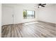 Bright living room featuring wood-look tile flooring, a ceiling fan, and a large window at 11030 N 47Th Ave, Glendale, AZ 85304