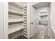 Well-organized pantry with built-in shelving, next to a kitchen with wood-look tile flooring at 11030 N 47Th Ave, Glendale, AZ 85304