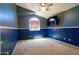 Carpeted bedroom with blue accent wall, a ceiling fan, and a window for plenty of sunlight at 111 N Soho Pl, Chandler, AZ 85225