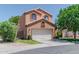 Two-story home with a front garage and lush green lawn with foliage at 111 N Soho Pl, Chandler, AZ 85225
