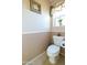 Powder room with toilet, neutral paint, tile floor, and decorative accents at 111 N Soho Pl, Chandler, AZ 85225