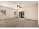 Bright living room featuring neutral carpet, ceiling fan, and sliding glass door at 11303 E Sunflower Ct, Florence, AZ 85132
