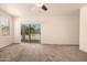 Bright living room featuring neutral carpet, ceiling fan, and sliding glass door at 11303 E Sunflower Ct, Florence, AZ 85132