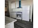 Bright kitchen featuring white cabinets, appliances, and a modern vent hood at 11411 N 91St Ave # 188, Peoria, AZ 85345