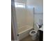 View of a tub-shower combination with tile walls, next to a toilet and vanity with a small window above at 11936 W Charter Oak Rd, El Mirage, AZ 85335