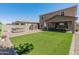 Well-maintained backyard featuring a covered patio, a hot tub, and green artificial turf at 12236 W Country Club Ct, Sun City, AZ 85373