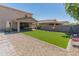 Large backyard with artificial grass, a covered patio, and a view of the house at 12236 W Country Club Ct, Sun City, AZ 85373