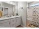 Bathroom featuring a vanity with white cabinets and countertop, and a shower with a colorful curtain at 12236 W Country Club Ct, Sun City, AZ 85373