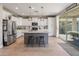 Modern kitchen featuring white cabinets, stainless steel appliances, an island, and a sliding glass door to the backyard at 12236 W Country Club Ct, Sun City, AZ 85373