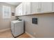 Laundry room featuring a modern washer and dryer, white cabinets, and a window for natural light at 12236 W Country Club Ct, Sun City, AZ 85373
