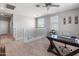 Second floor loft featuring a ceiling fan, natural light, and a dark wooden desk with a glass top at 12236 W Country Club Ct, Sun City, AZ 85373