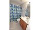 Bathroom featuring a blue and green shower curtain, a single sink vanity, and tiled floors at 14861 W Ashland Ave, Goodyear, AZ 85395