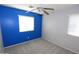 Bedroom featuring neutral carpet, ceiling fan, and blue accent wall at 14861 W Ashland Ave, Goodyear, AZ 85395