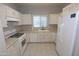 Bright kitchen with white appliances, ample counter space, and a window overlooking the sink at 14861 W Ashland Ave, Goodyear, AZ 85395