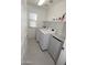 Bright laundry room with modern appliances, storage shelf and a window at 14861 W Ashland Ave, Goodyear, AZ 85395