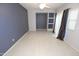 Open-concept living area with tile flooring, neutral tones, a built-in shelf, and a contemporary ceiling fan at 14861 W Ashland Ave, Goodyear, AZ 85395