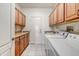 Efficient laundry room equipped with ample cabinet space, a sink, and modern washer and dryer units at 15532 W Prairie Dunes Dr, Surprise, AZ 85374