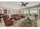 Cozy living room with comfortable seating, ceiling fan, and large windows at 15532 W Prairie Dunes Dr, Surprise, AZ 85374