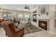 Comfortable living room featuring a cozy fireplace, entertainment center, and views of the outdoor patio at 15532 W Prairie Dunes Dr, Surprise, AZ 85374
