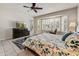 A spacious main bedroom features a view to the backyard, ceiling fan, large windows with shutters, and tiled floors at 15532 W Prairie Dunes Dr, Surprise, AZ 85374