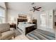 The main bedroom features tile floors, ceiling fan, and large windows with shutters for a bright, airy space at 15532 W Prairie Dunes Dr, Surprise, AZ 85374