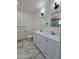 Bright bathroom featuring a dual sink vanity, sleek fixtures, and elegant marble-style tile flooring at 1627 W Pueblo Ave, Mesa, AZ 85202