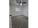 This carpeted bedroom features a ceiling fan and natural light from the window at 1627 W Pueblo Ave, Mesa, AZ 85202