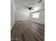 Well-lit living space showcasing new flooring, a ceiling fan, and a large window at 1627 W Pueblo Ave, Mesa, AZ 85202