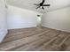 Spacious living room with modern plank flooring, a ceiling fan, and freshly painted white walls at 1627 W Pueblo Ave, Mesa, AZ 85202