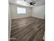 Bright living room with neutral walls, ceiling fan, new plank flooring, and a white door at 1627 W Pueblo Ave, Mesa, AZ 85202
