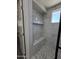 Elegant shower equipped with tiled bench, shelves and decorative pebble flooring and white marble-style tile walls at 1627 W Pueblo Ave, Mesa, AZ 85202