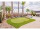 Private backyard oasis with putting green, lounge seating and mature palm trees at 16781 W Northampton Rd, Surprise, AZ 85374