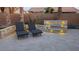 Backyard patio with lounge chairs and outdoor fireplace feature, surrounded by desert landscaping at 16781 W Northampton Rd, Surprise, AZ 85374